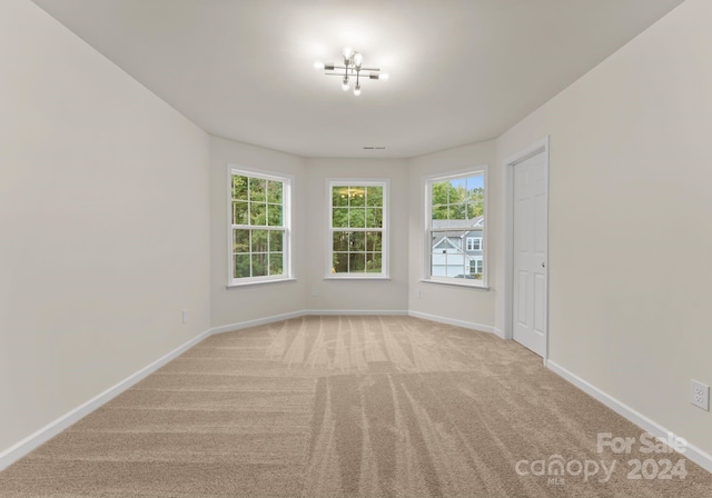 carpeted spare room featuring baseboards