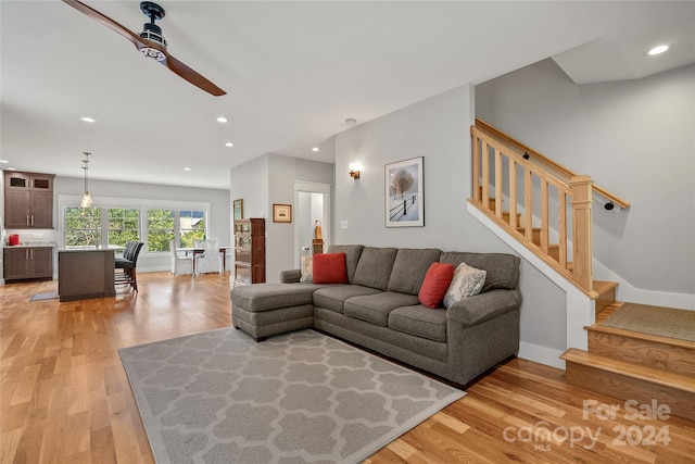 living room with ceiling fan and light wood-type flooring