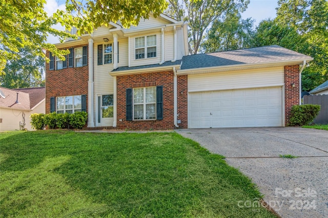 view of property featuring a front lawn and a garage