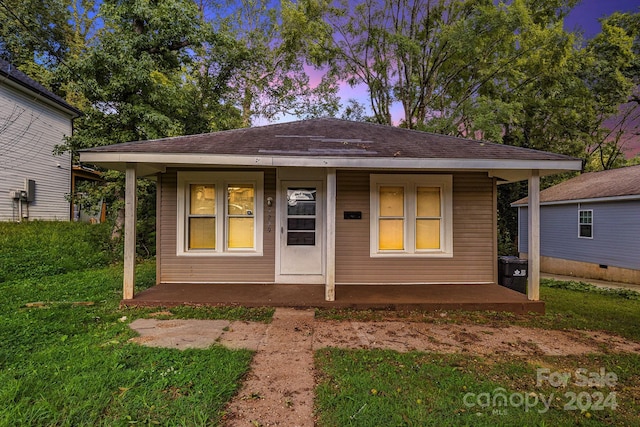 bungalow-style home featuring a yard and covered porch