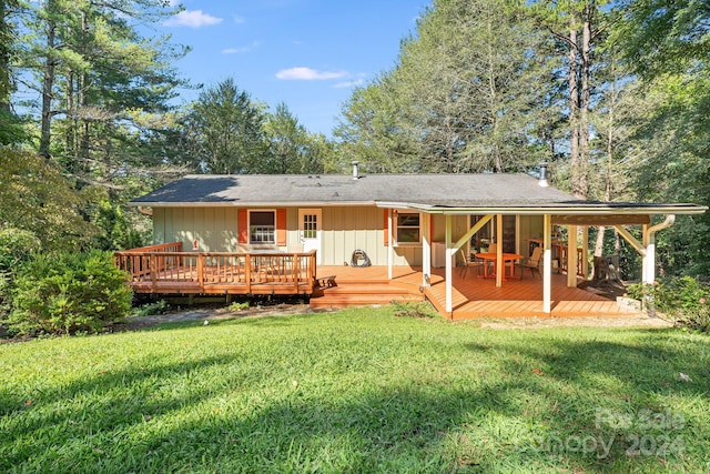 back of house featuring a lawn and a wooden deck