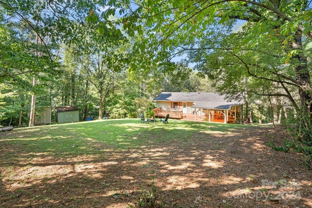 view of yard with a wooden deck and a shed