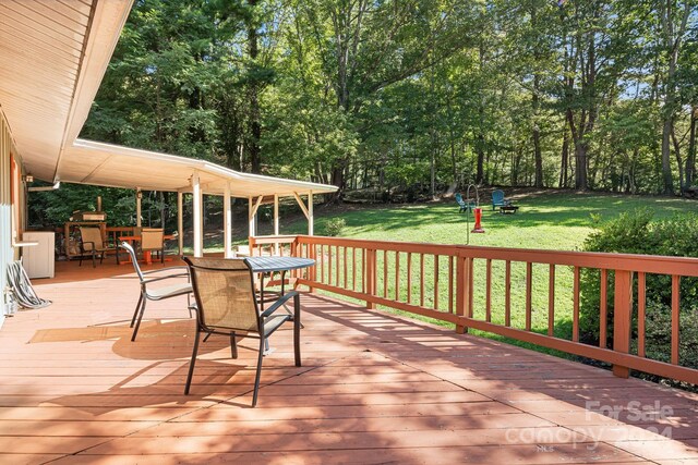 wooden terrace featuring a yard