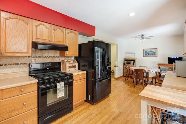 kitchen with light wood-type flooring, black appliances, tasteful backsplash, and ceiling fan