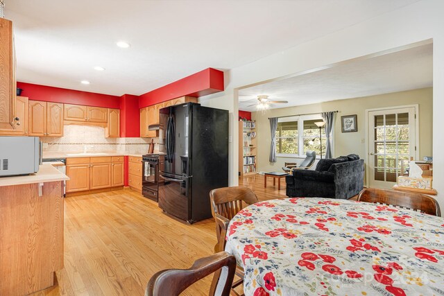 dining area with ceiling fan, sink, and light hardwood / wood-style flooring