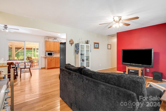 living room featuring light hardwood / wood-style flooring and ceiling fan