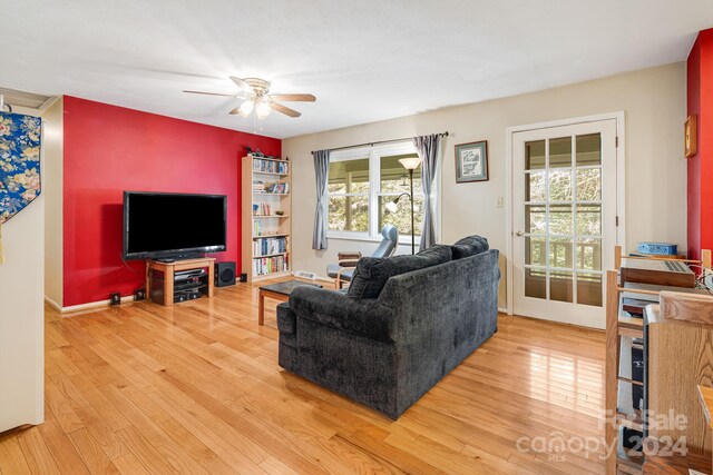 living room with light hardwood / wood-style flooring, a healthy amount of sunlight, and ceiling fan