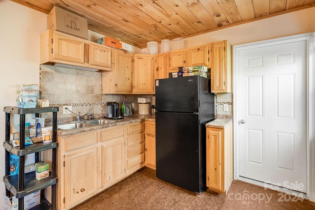 kitchen featuring black refrigerator, wood ceiling, light brown cabinets, and tasteful backsplash