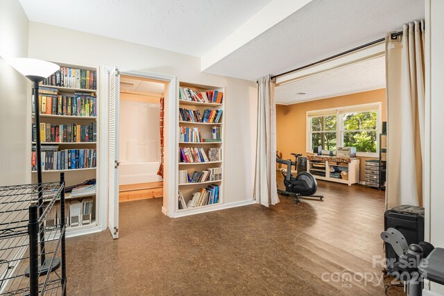 misc room with wood-type flooring and a textured ceiling