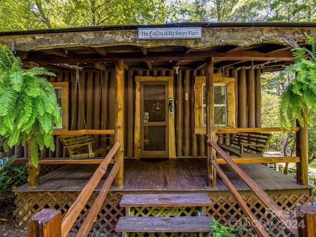 view of exterior entry featuring a wooden deck