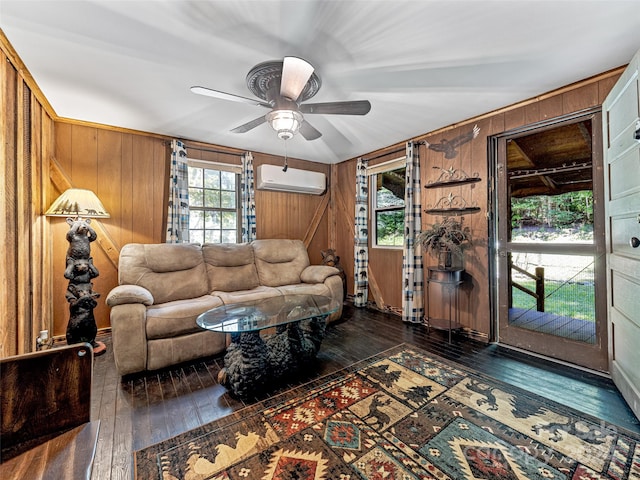 living room featuring dark hardwood / wood-style flooring, wood walls, a wall mounted air conditioner, and ceiling fan