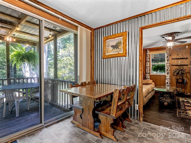 dining room featuring ceiling fan, ornamental molding, a textured ceiling, and wood-type flooring