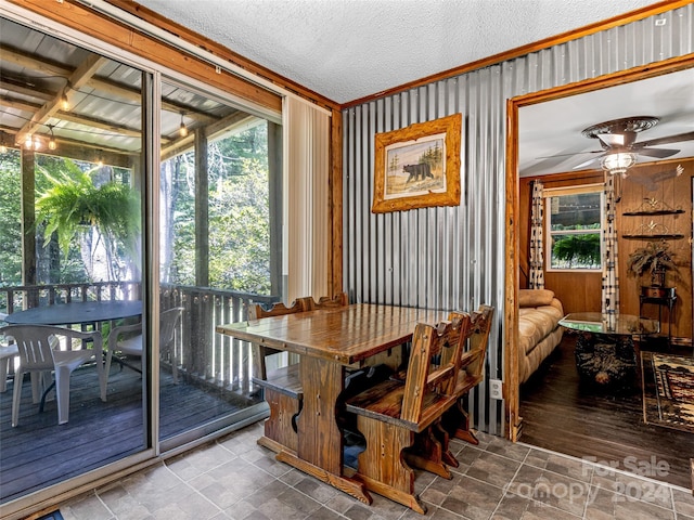dining space featuring crown molding, ceiling fan, and a textured ceiling