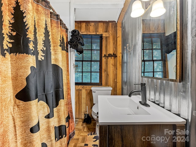 bathroom featuring wooden walls, toilet, parquet floors, and vanity