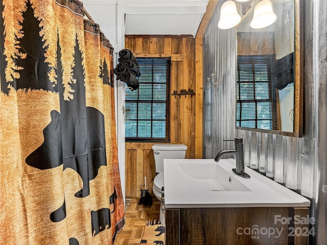 bathroom featuring wood walls, vanity, and toilet