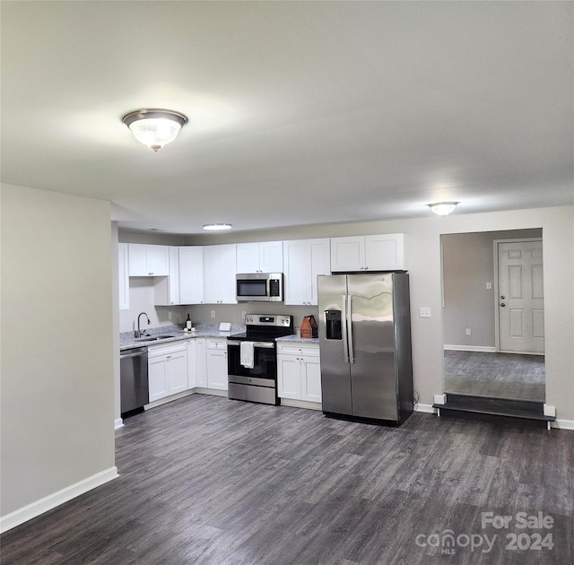 kitchen featuring stainless steel appliances, dark wood-style flooring, a sink, and white cabinetry