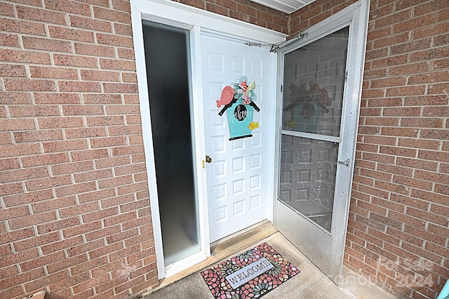 doorway to property with brick siding