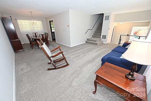 carpeted living room featuring an inviting chandelier and a textured ceiling