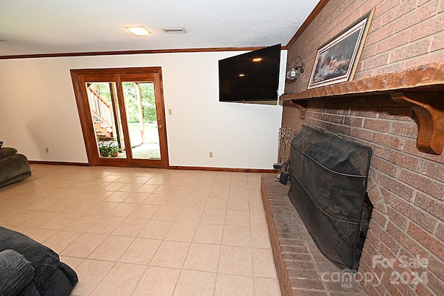 living room with light tile patterned floors, a textured ceiling, baseboards, and crown molding