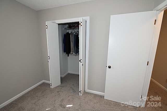 unfurnished bedroom with light carpet, baseboards, and a closet