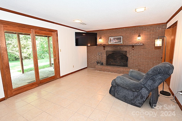 living area with a fireplace, light tile patterned floors, ornamental molding, a textured ceiling, and brick wall