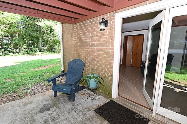 entrance to property with a patio area and brick siding