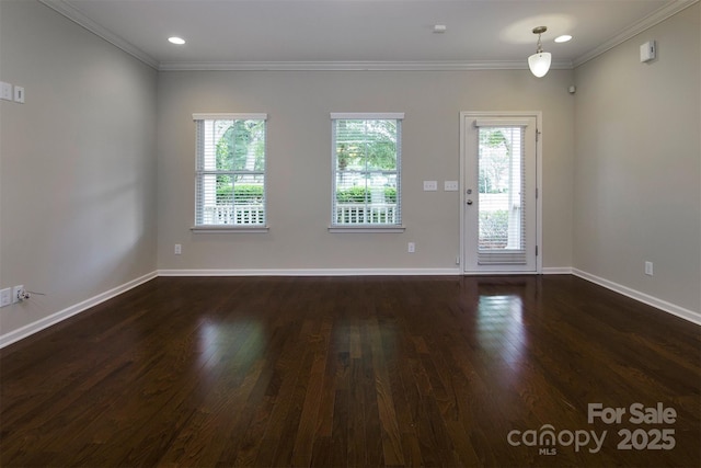 spare room with crown molding, a healthy amount of sunlight, and dark wood-type flooring