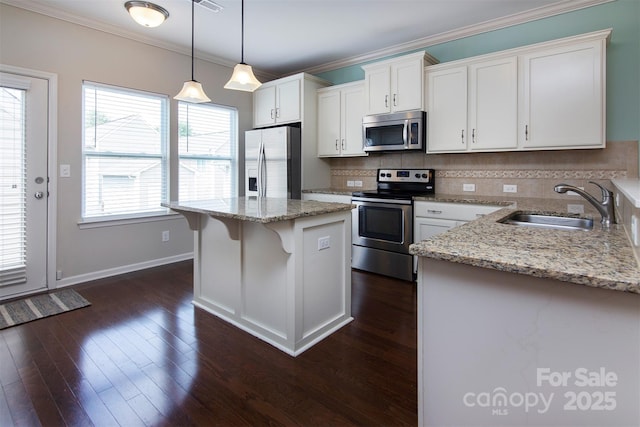 kitchen with sink, white cabinetry, appliances with stainless steel finishes, a kitchen island, and pendant lighting