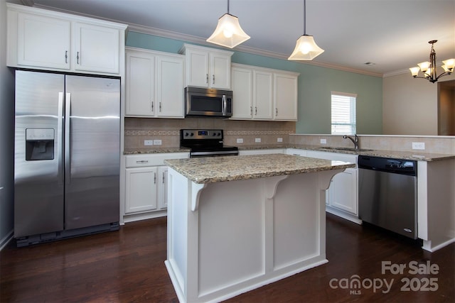 kitchen featuring white cabinetry, hanging light fixtures, and stainless steel appliances