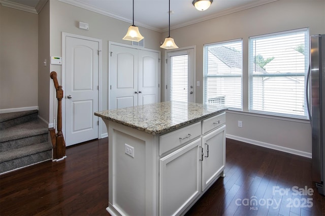 kitchen with white cabinetry, light stone counters, decorative light fixtures, dark hardwood / wood-style floors, and a kitchen island