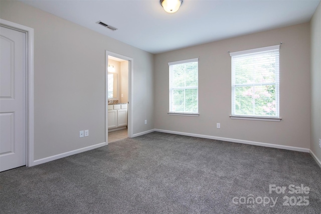 spare room with dark carpet