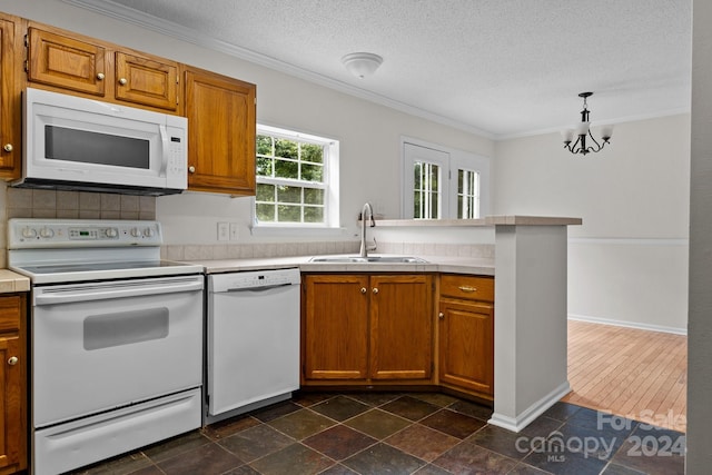 kitchen featuring sink, white appliances, ornamental molding, and dark tile patterned flooring