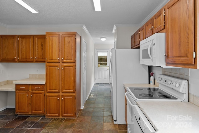 kitchen with dark tile patterned flooring, a textured ceiling, crown molding, and white appliances