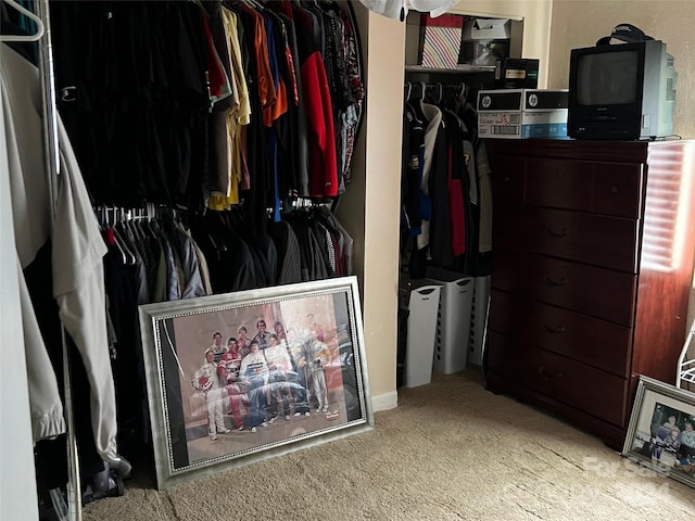 walk in closet featuring light colored carpet