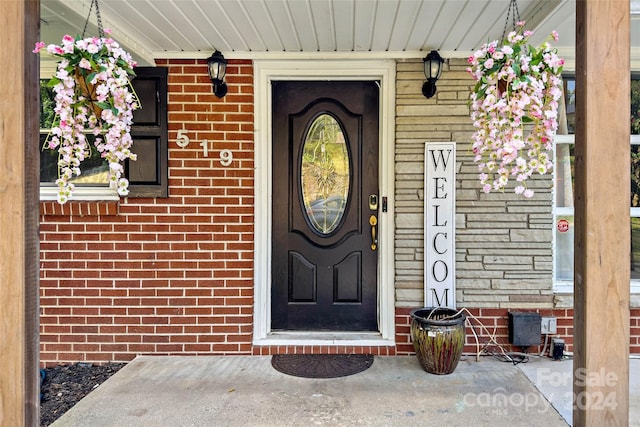 doorway to property featuring brick siding