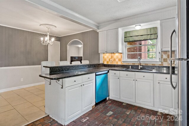 kitchen featuring sink, hanging light fixtures, decorative backsplash, stainless steel appliances, and white cabinets