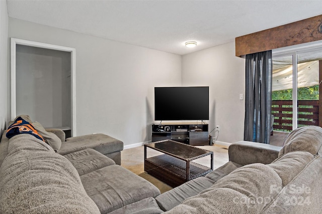 carpeted living area with baseboards