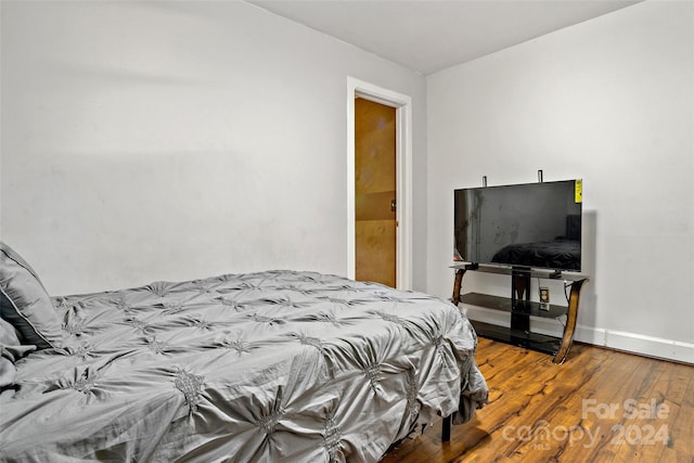 bedroom featuring baseboards and wood finished floors