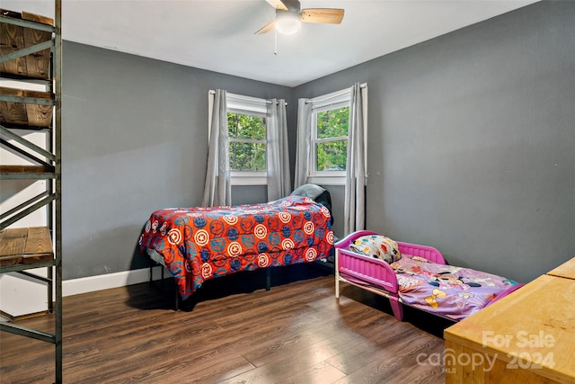 bedroom with ceiling fan, wood finished floors, and baseboards