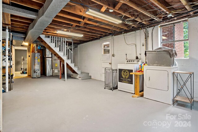 basement featuring washing machine and dryer and water heater