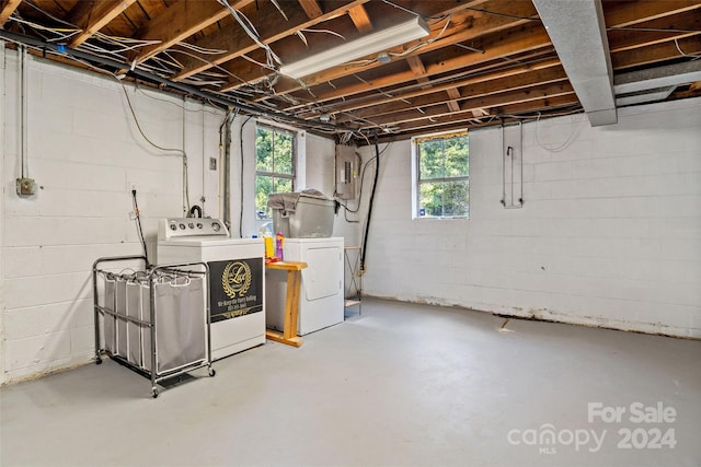 below grade area featuring plenty of natural light, washing machine and clothes dryer, and electric panel