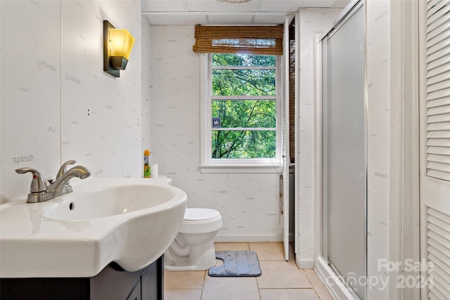 full bath with tile patterned floors, toilet, a shower stall, baseboards, and wallpapered walls