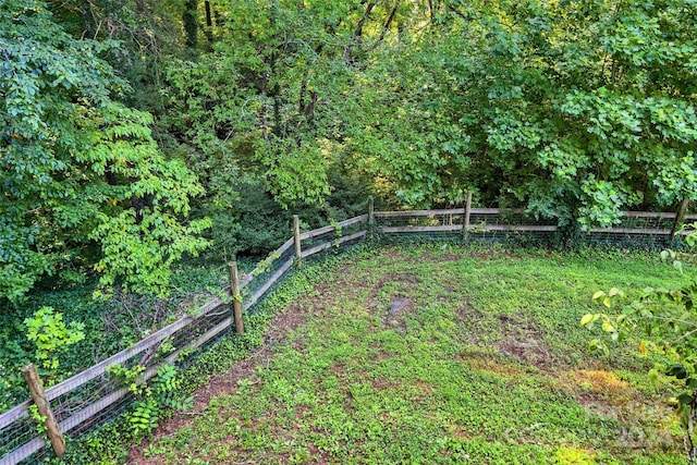 view of yard with fence and a wooded view