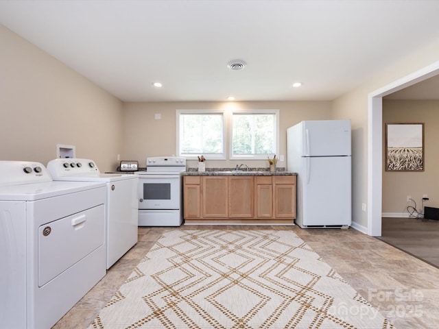 kitchen with white appliances, sink, and separate washer and dryer