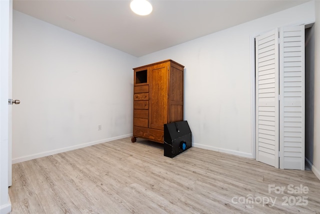 unfurnished bedroom with a closet and light wood-type flooring