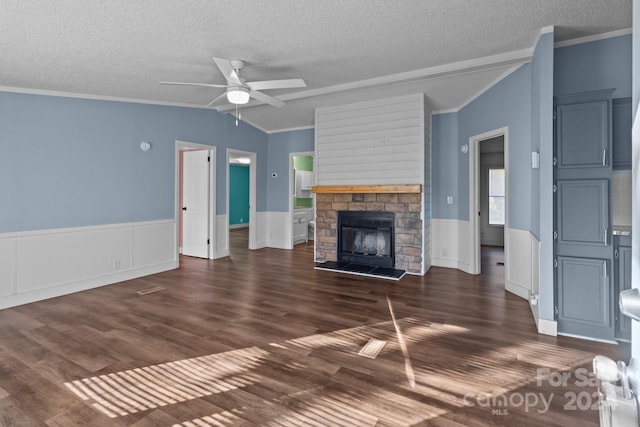 unfurnished living room with lofted ceiling, a fireplace, dark hardwood / wood-style flooring, ornamental molding, and ceiling fan