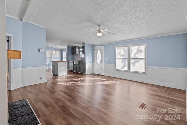 unfurnished living room featuring ceiling fan, sink, a textured ceiling, hardwood / wood-style flooring, and vaulted ceiling