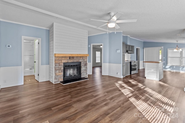 unfurnished living room with a healthy amount of sunlight, dark wood-type flooring, and a stone fireplace