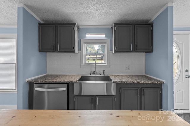 kitchen with a textured ceiling, decorative backsplash, dishwasher, and sink