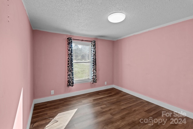 unfurnished room featuring ornamental molding, a textured ceiling, and dark hardwood / wood-style flooring